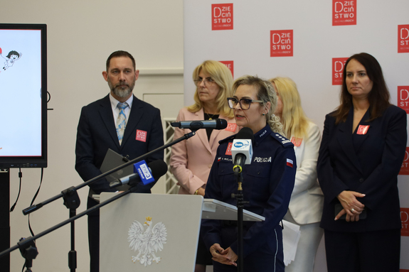 obraz przedstawia konferencję, przemowę policjantki.